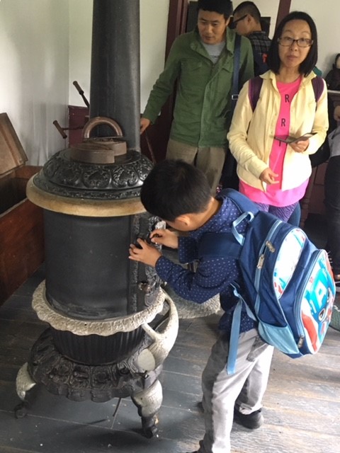 A kid trying to open one of the wooden stoves